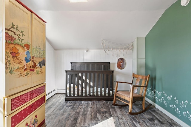 bedroom with vaulted ceiling, baseboard heating, baseboards, and wood finished floors