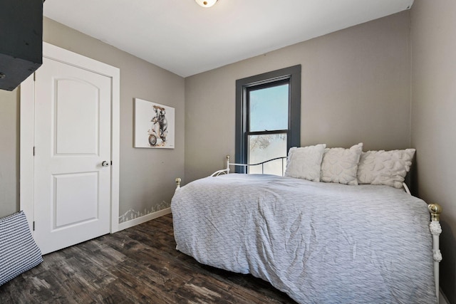 bedroom with baseboards and dark wood-style floors