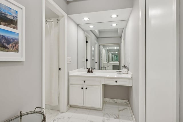 bathroom with baseboards, marble finish floor, vanity, and recessed lighting