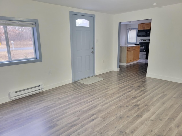 entryway featuring light wood finished floors, a baseboard radiator, and baseboards