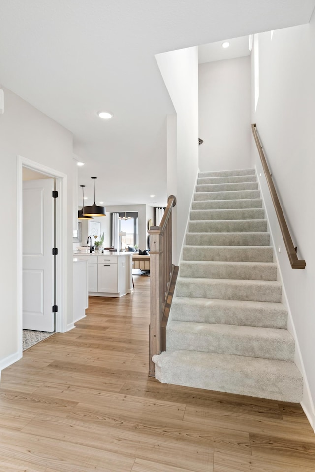 stairs with recessed lighting, baseboards, and wood finished floors