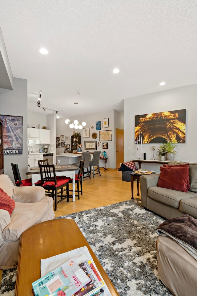 living area featuring light wood-style floors, a textured ceiling, and recessed lighting