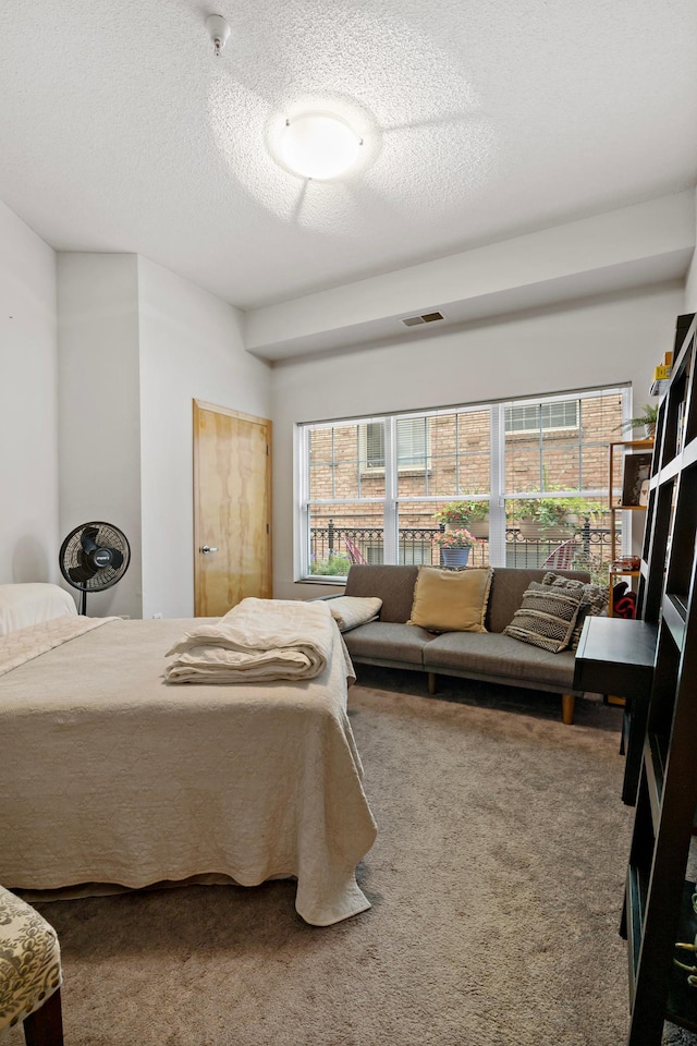 carpeted bedroom featuring visible vents and a textured ceiling