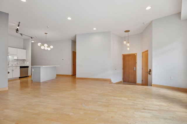 308 18th St Unit 101, Minneapolis, MN 55404 - unfurnished living room featuring recessed lighting, light wood finished floors, a towering ceiling, and baseboards