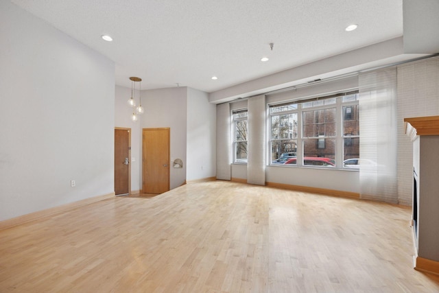 308 18th St Unit 101, Minneapolis, MN 55404 - unfurnished living room with baseboards, recessed lighting, wood finished floors, and a fireplace