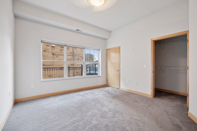 308 18th St Unit 101, Minneapolis, MN 55404 - unfurnished bedroom with carpet flooring, baseboards, a spacious closet, and visible vents