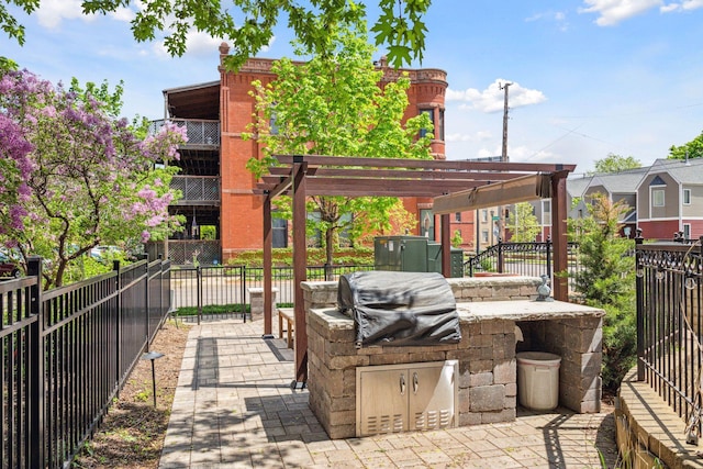 308 18th St Unit 101, Minneapolis, MN 55404 - view of patio / terrace with a pergola, an outdoor kitchen, grilling area, and fence