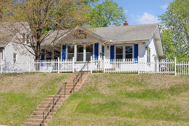 bungalow-style house with stairs, a chimney, fence, and a shingled roof