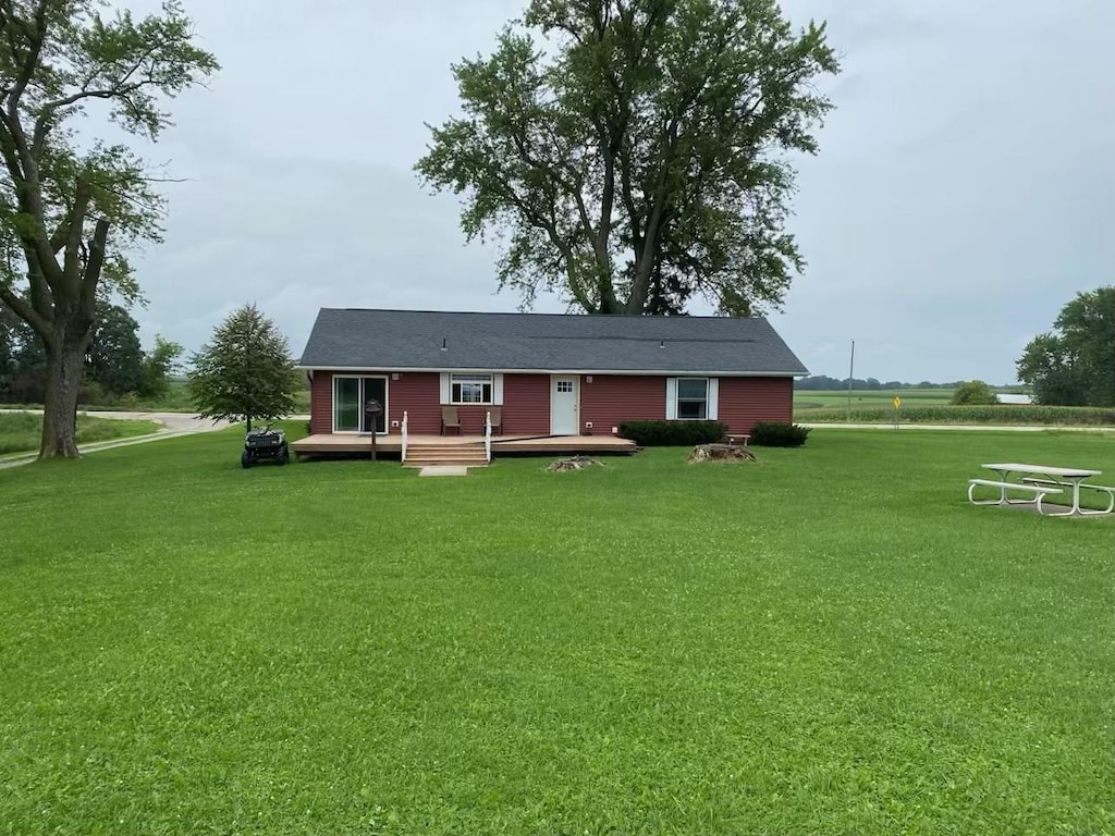 back of property featuring a lawn and a wooden deck