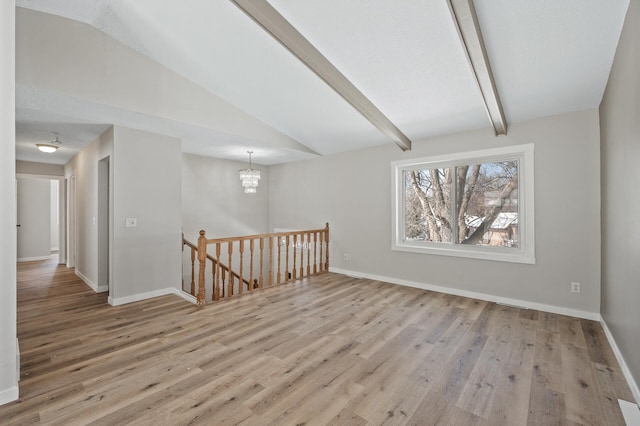 unfurnished room featuring a notable chandelier, vaulted ceiling with beams, baseboards, and wood finished floors