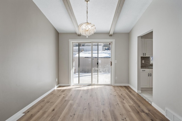 unfurnished dining area with visible vents, baseboards, light wood-style floors, beamed ceiling, and a notable chandelier