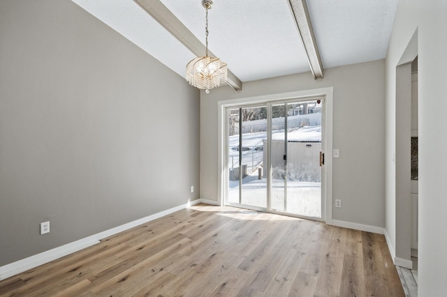 unfurnished dining area with beam ceiling, a chandelier, light wood-type flooring, and baseboards