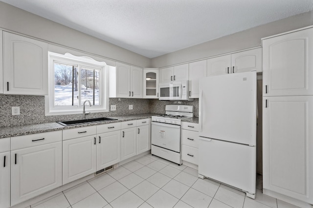 kitchen featuring a sink, glass insert cabinets, white appliances, and tasteful backsplash