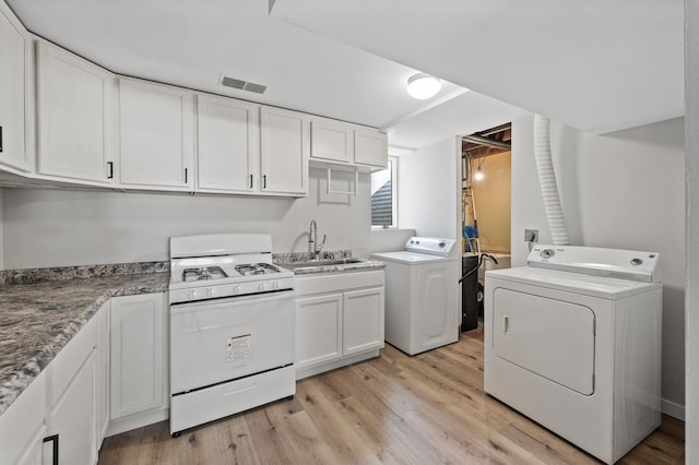 laundry area featuring a sink, visible vents, separate washer and dryer, and laundry area