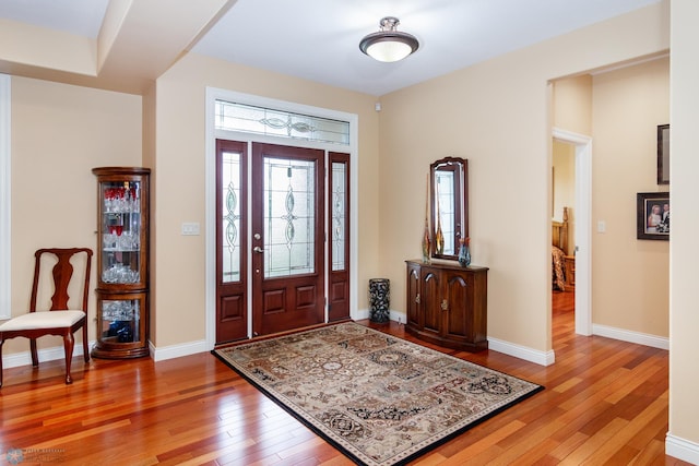 foyer entrance featuring hardwood / wood-style floors and baseboards