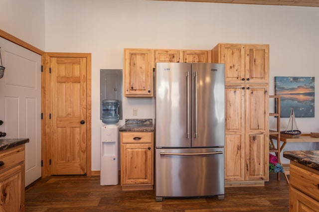 kitchen with high end fridge, dark countertops, and dark wood finished floors