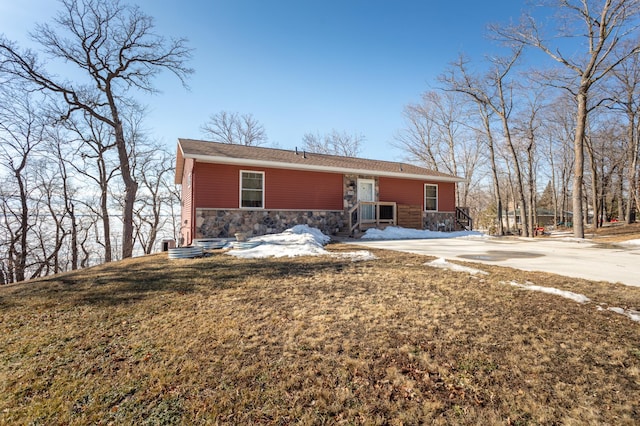 view of front of property featuring stone siding and a front lawn