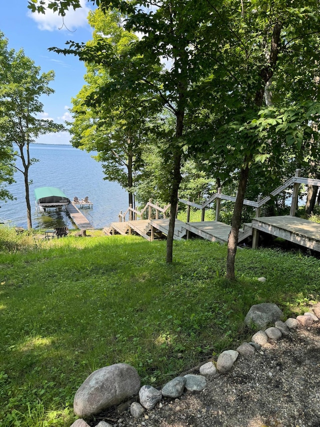 view of yard featuring a boat dock and a water view