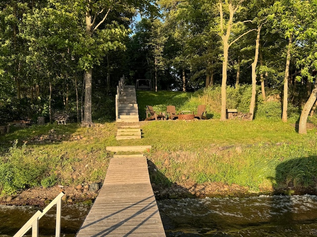 view of yard with stairs and a dock