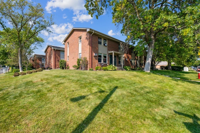 exterior space with brick siding and a lawn