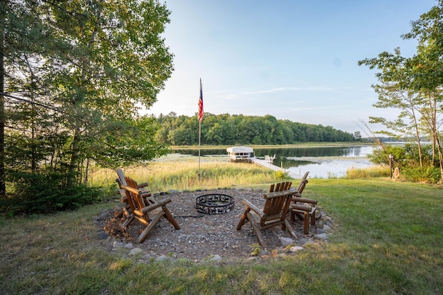 view of yard featuring a fire pit, a boat dock, and a water view