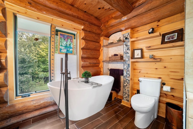 full bath featuring a wealth of natural light, a soaking tub, log walls, and wood tiled floor