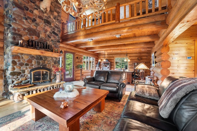 living room with a high ceiling, a fireplace, wood finished floors, beamed ceiling, and an inviting chandelier