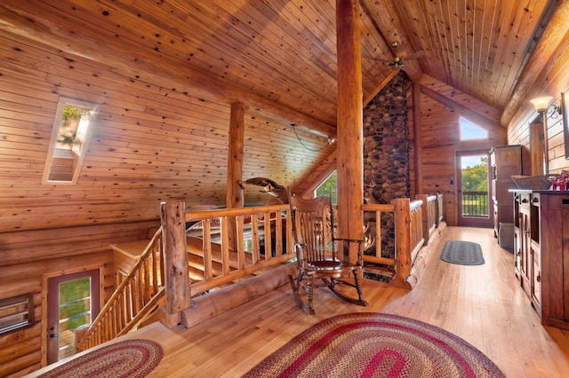 living area featuring wooden ceiling, log walls, hardwood / wood-style floors, and an upstairs landing