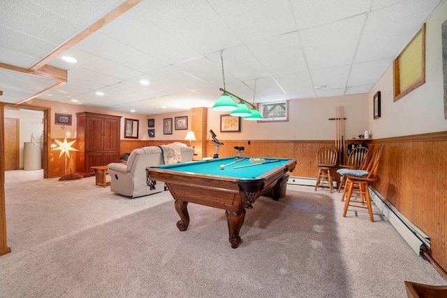 game room featuring carpet floors, wood walls, a drop ceiling, and wainscoting