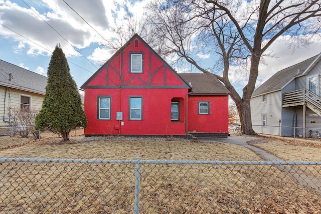 view of side of property with a fenced front yard and stucco siding