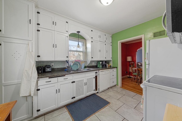 kitchen with decorative backsplash, white cabinets, and white appliances