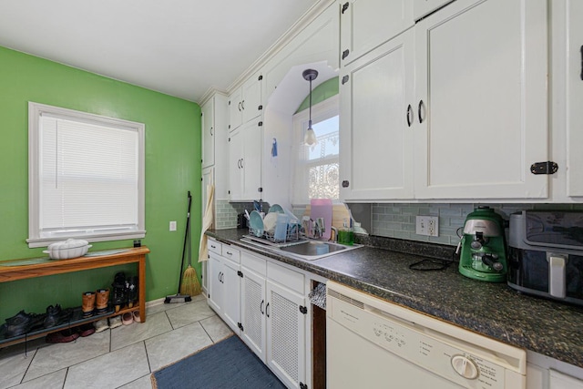 kitchen featuring light tile patterned floors, white cabinets, dishwasher, dark countertops, and tasteful backsplash