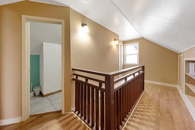 additional living space with vaulted ceiling, wood finished floors, and baseboards