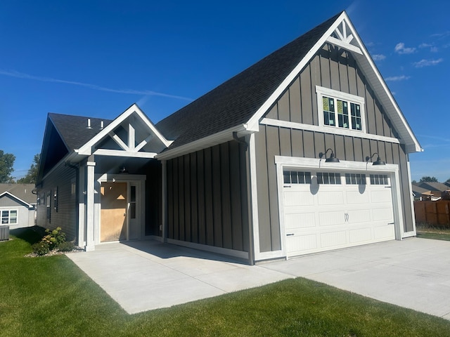 exterior space with board and batten siding, concrete driveway, roof with shingles, and a garage