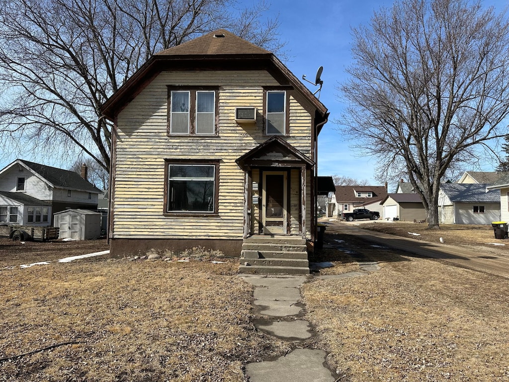 view of front of house with a storage unit and an outbuilding