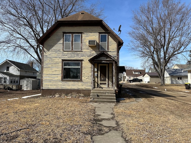 view of front of house with a storage unit and an outbuilding