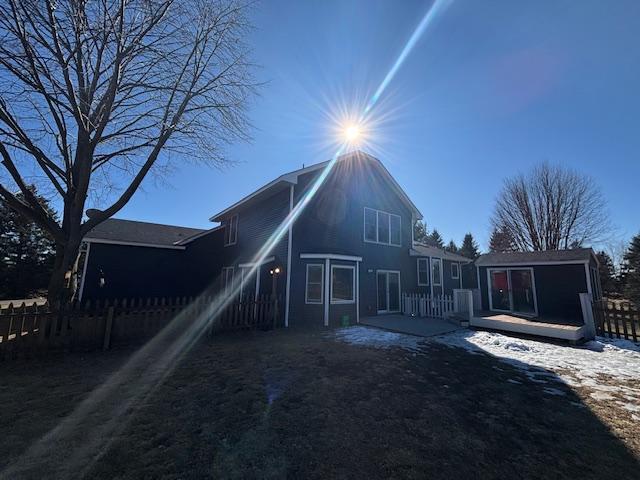 back of property with a deck and fence