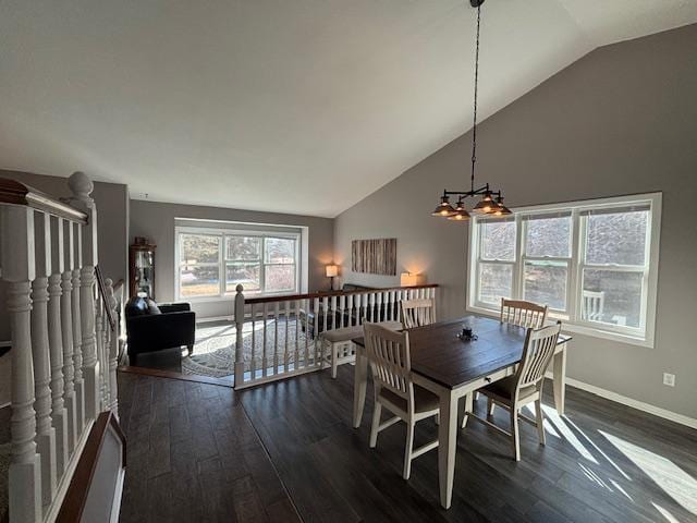 dining space with high vaulted ceiling, dark wood finished floors, and baseboards