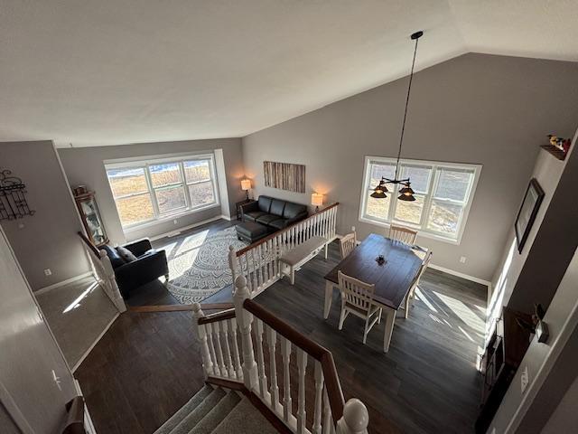 interior space featuring lofted ceiling, baseboards, and wood finished floors