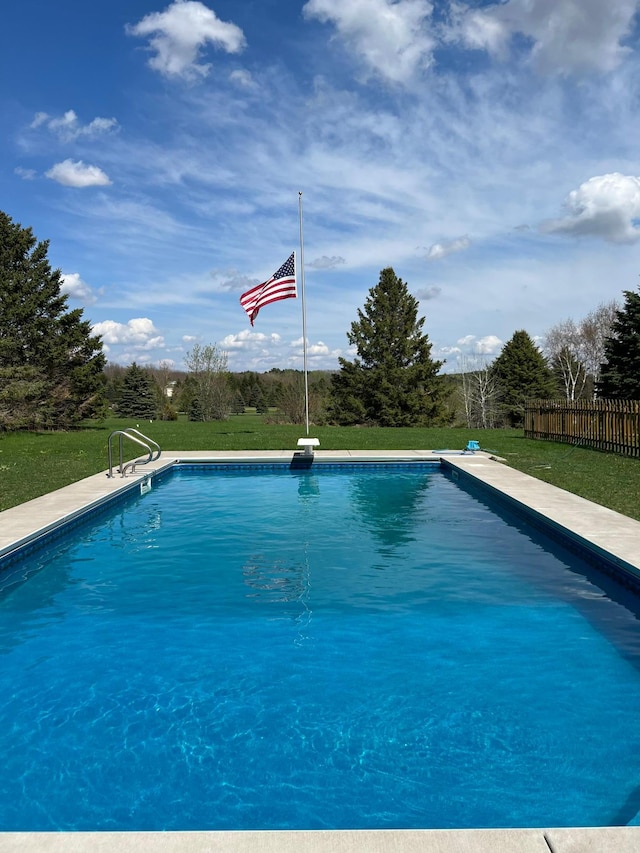 pool with a yard and fence