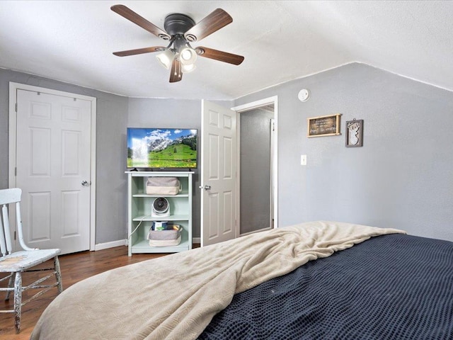 bedroom featuring vaulted ceiling, wood finished floors, a ceiling fan, and baseboards