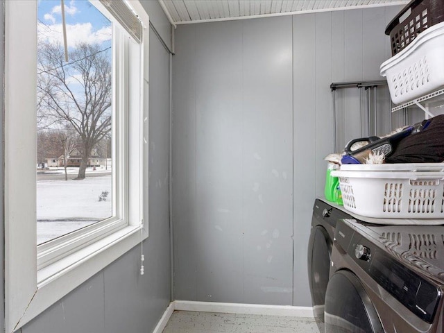 washroom featuring laundry area, washer and clothes dryer, and baseboards