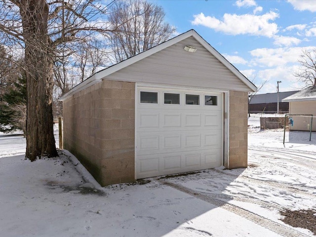 snow covered garage with a garage