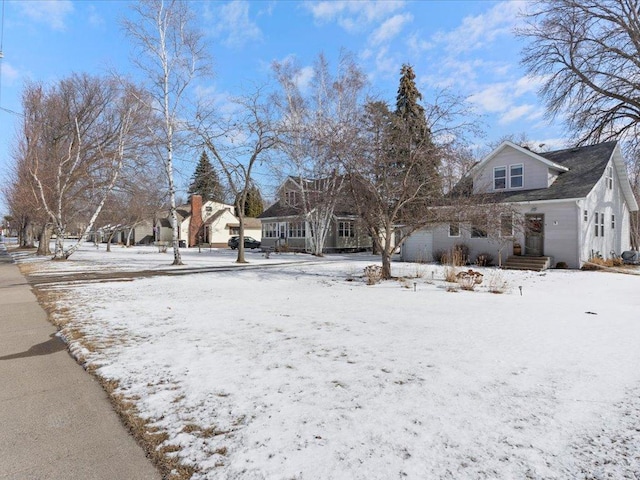 yard layered in snow with a garage and a residential view