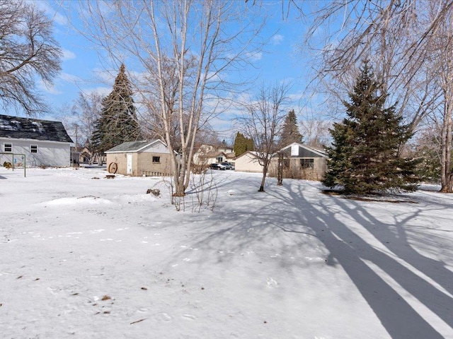 snowy yard with an outbuilding