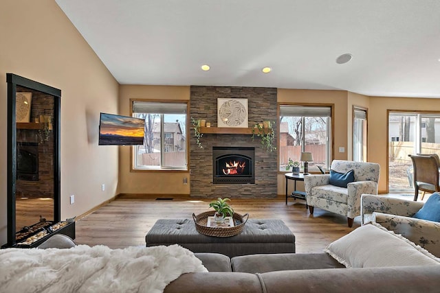 living area with a healthy amount of sunlight, wood finished floors, and a fireplace