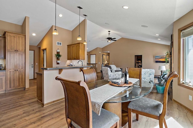 dining area with visible vents, lofted ceiling, light wood-style flooring, and a ceiling fan