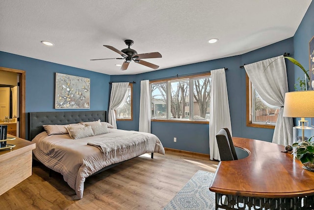 bedroom with ceiling fan, a textured ceiling, wood finished floors, and recessed lighting