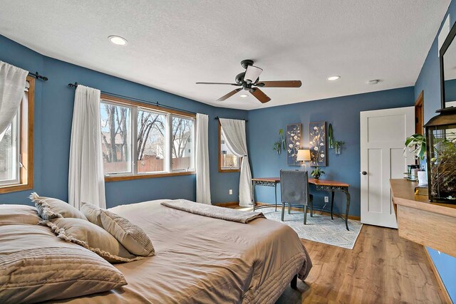 bedroom with recessed lighting, a textured ceiling, baseboards, and wood finished floors