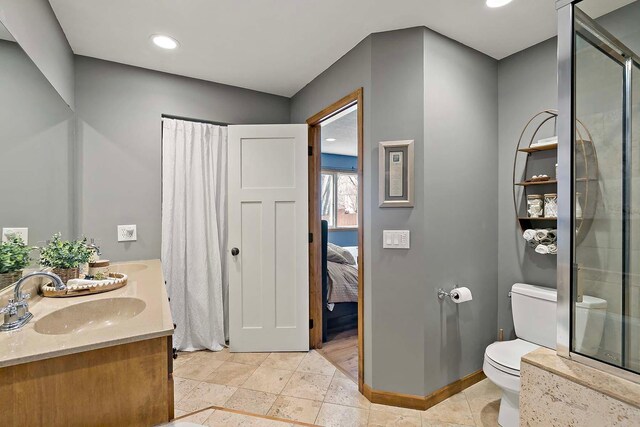 full bath with baseboards, ensuite bath, a sink, toilet, and a shower with door